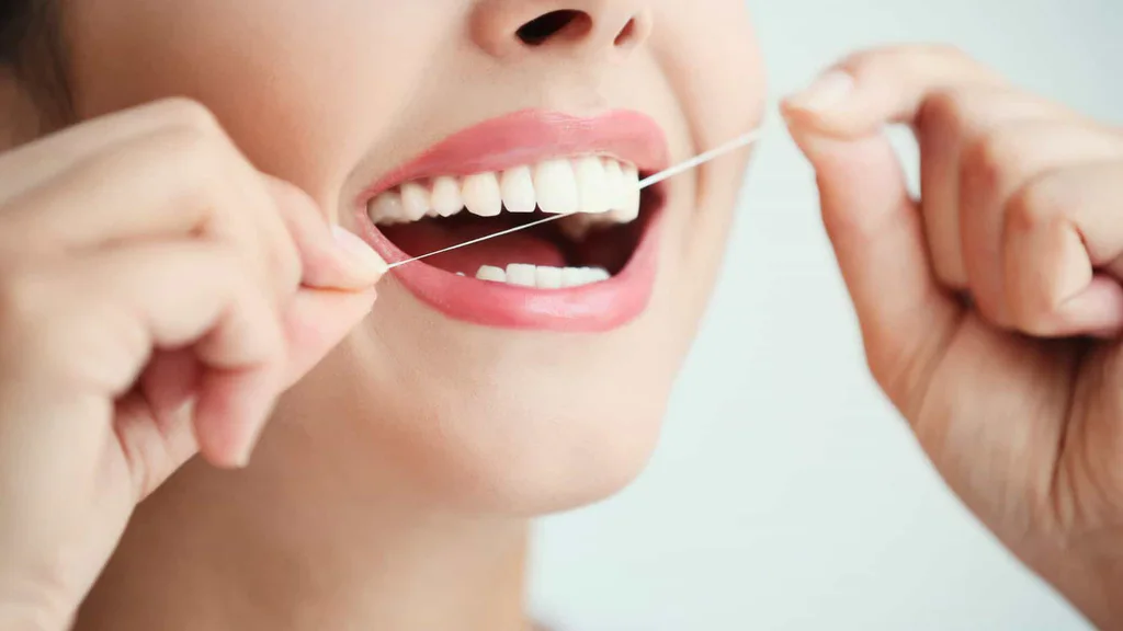 A woman flossing her teeth