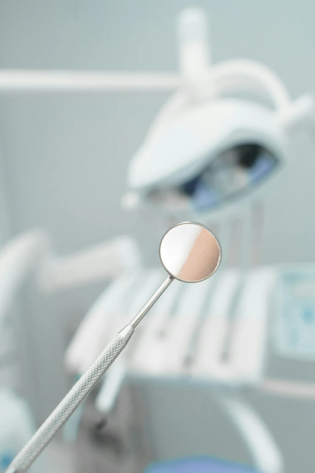 A dental mirror in soft focus in a clinic