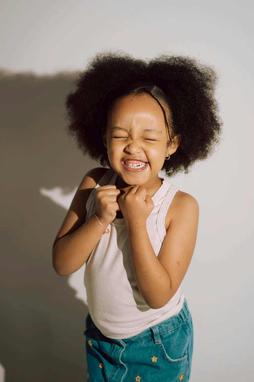A young girl laughing with a wide, gap-toothed smile