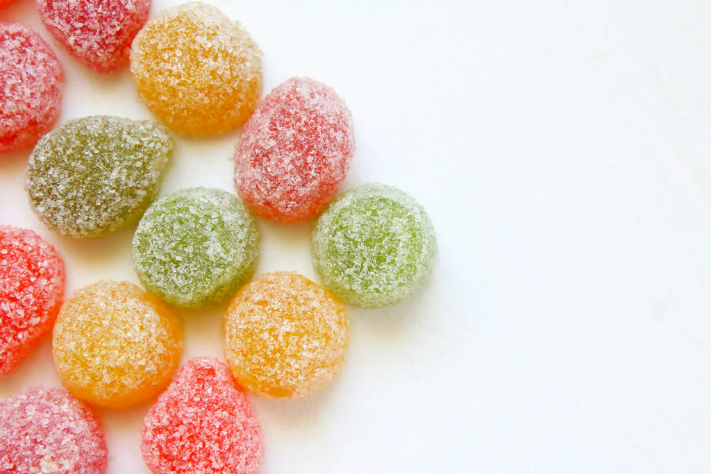 Sugar-coated candies scattered on a white surface