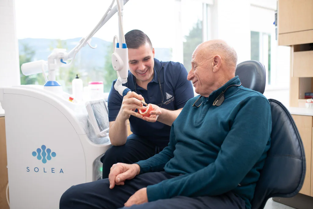 Dr. Séguin and a smiling patient beside the Solea laser at Seven Sails