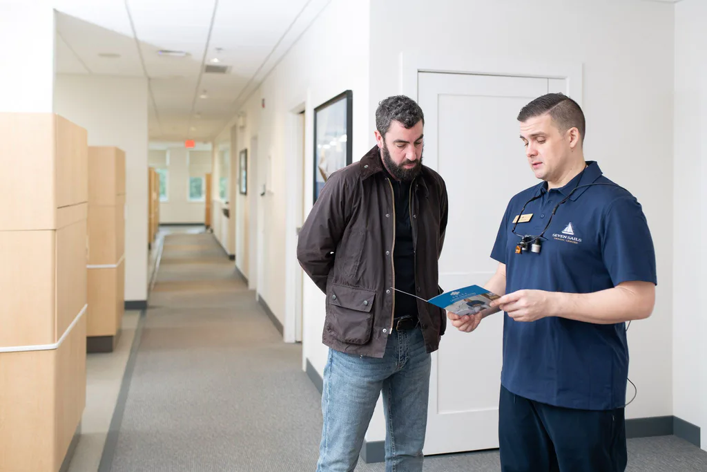 Dr. Séguin chatting with a patient in the bright hallway