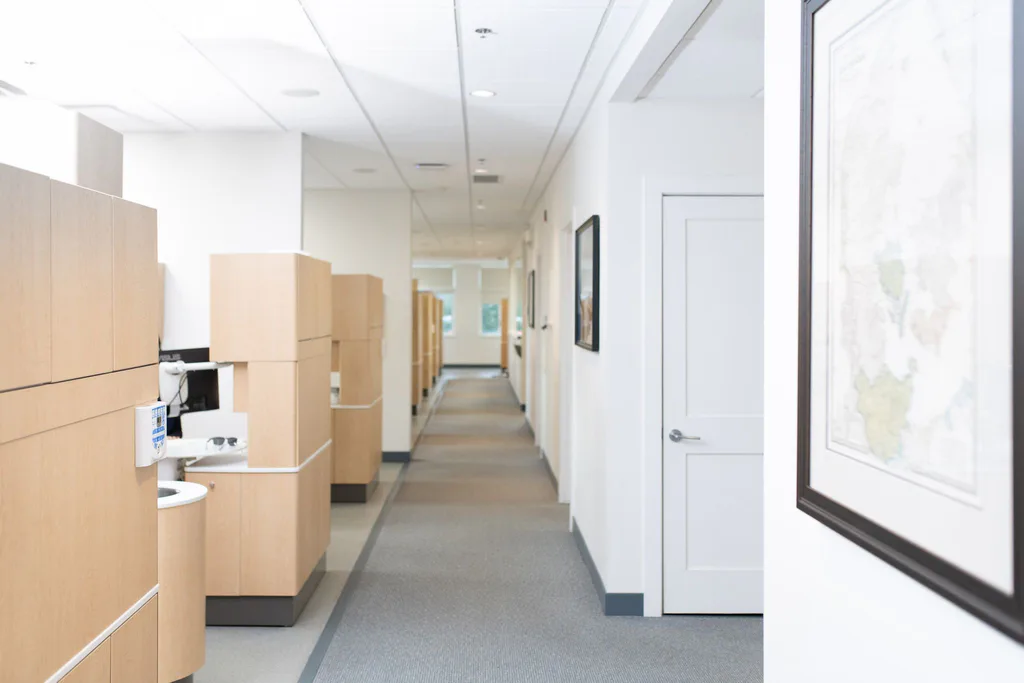 A long, bright hallway lined with wood cabinetry