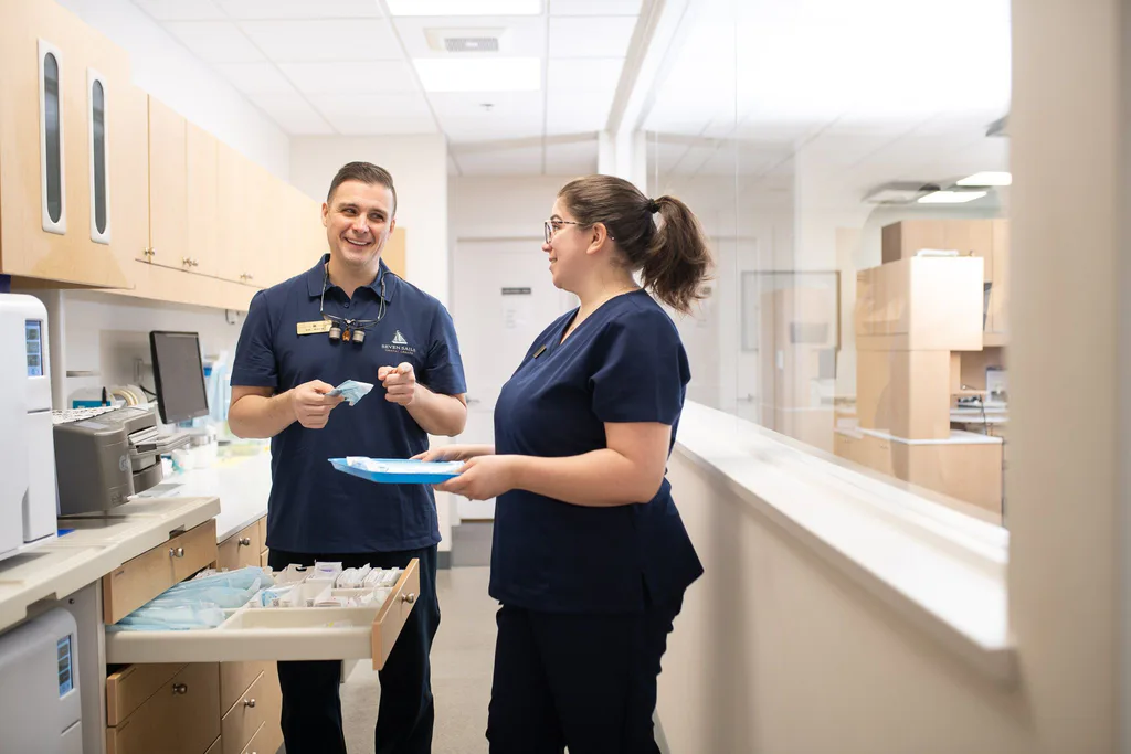 Dr. Séguin and an assistant laughing together while preparing instruments
