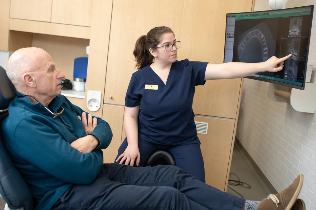A hygienist pointing out details on a patient's 3D scan